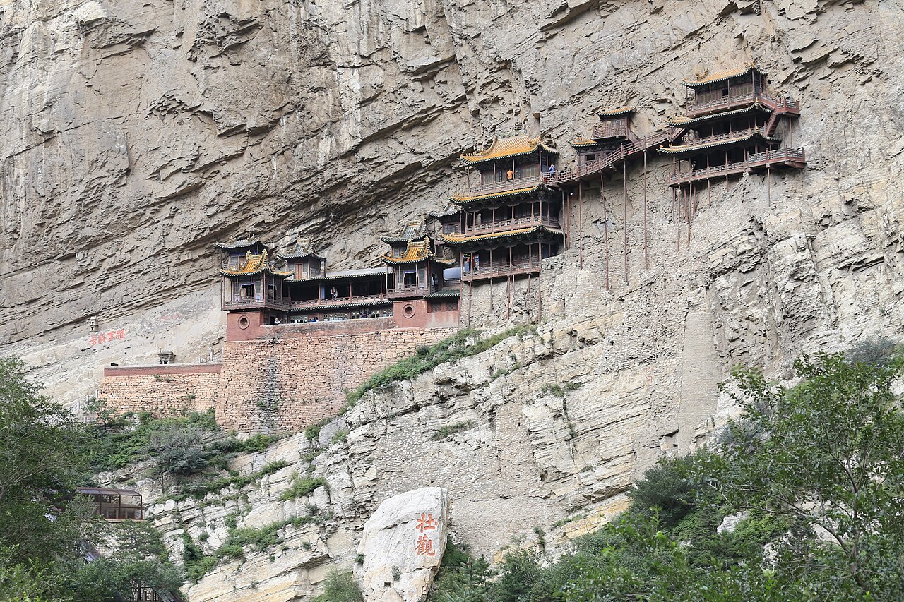 The Hanging Temple's halls and walkways cling halfway up a sheer cliff face near Mount Heng, braced on wooden stilts above the gorge.