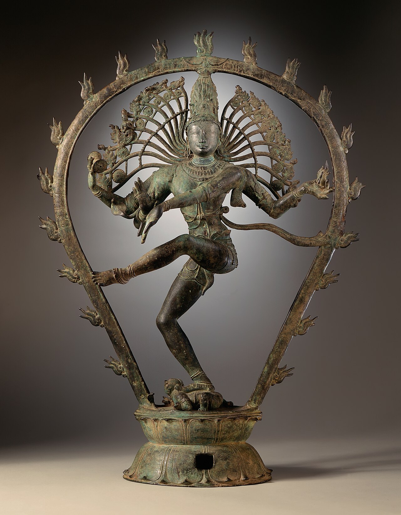 A Chola-dynasty bronze of Shiva as Nataraja, Lord of the Dance, dancing within a ring of flames on a lotus pedestal.