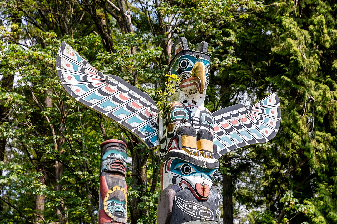 Painted formline figures crown the Kakaso'Las totem pole at Stanley Park in Vancouver, a thunderbird spreading its wings at the top.