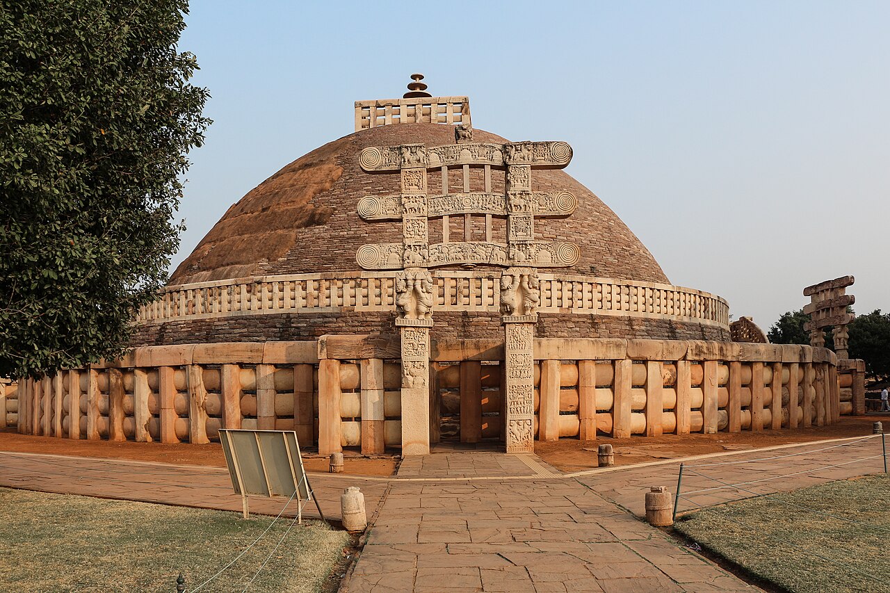 The Great Stupa at Sanchi, its brick dome ringed by a stone railing and fronted by an intricately carved gateway.