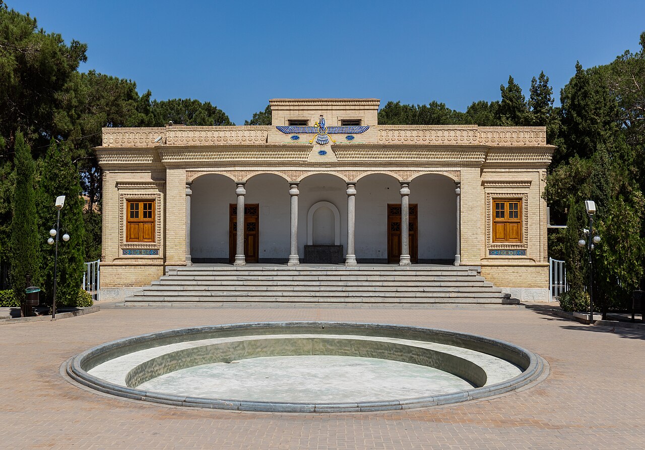 The Yazd Atash Behram fire temple stands behind its courtyard pool, a fravahar carved above the columned portico.