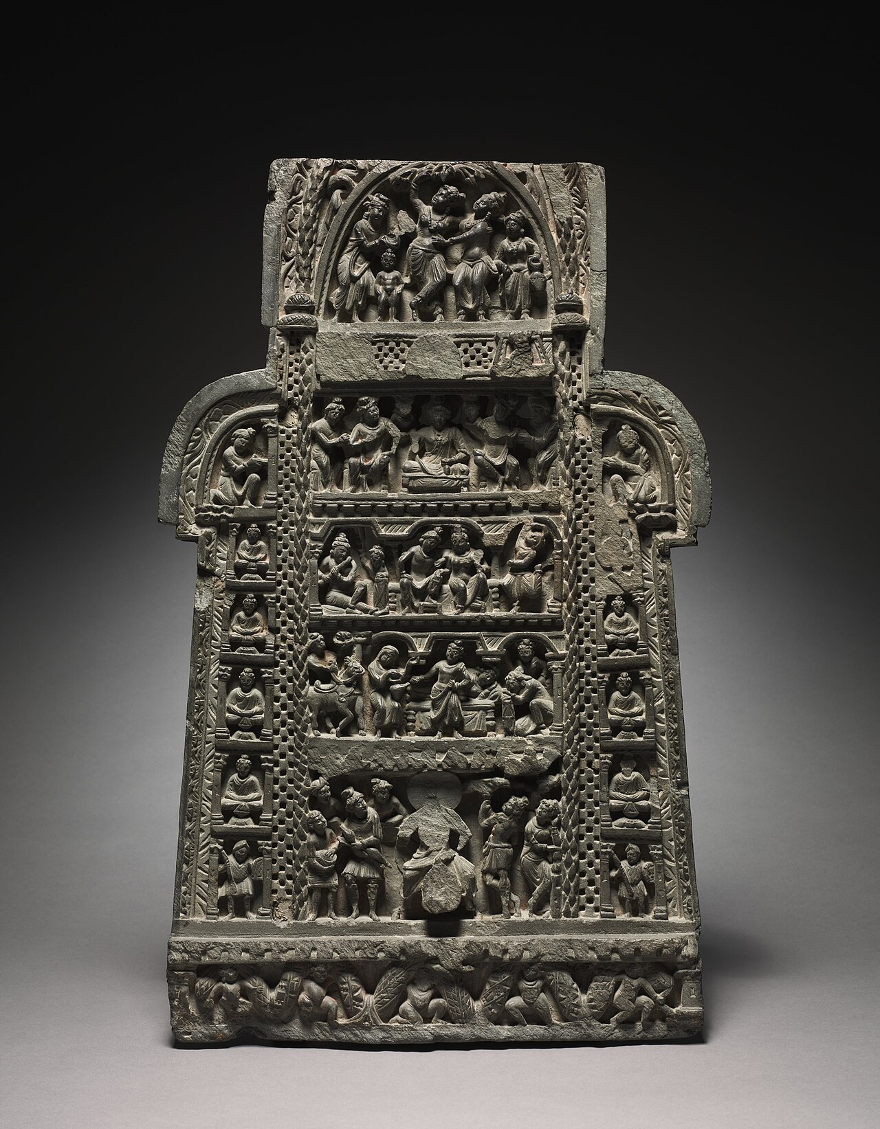 A Gandhara grey-schist relief panel carved in stacked registers with scenes from the life of the Buddha, from the Cleveland Museum of Art.