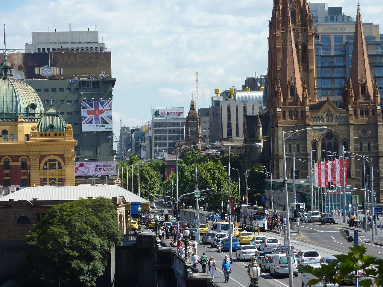 St Paul's Cathedral rising over Swanston Street in Melbourne, Flinders Street Station at the left.