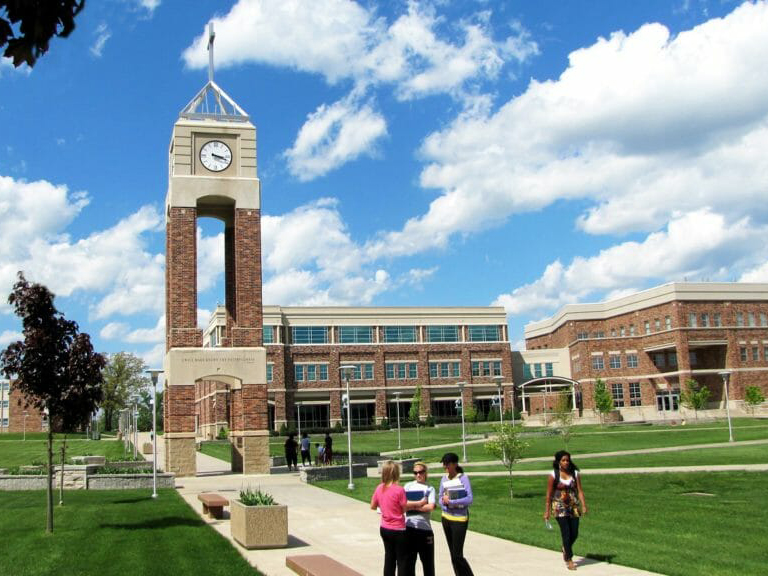 Evangel University's clock tower and green lawn in Springfield, Missouri, students walking the paths.