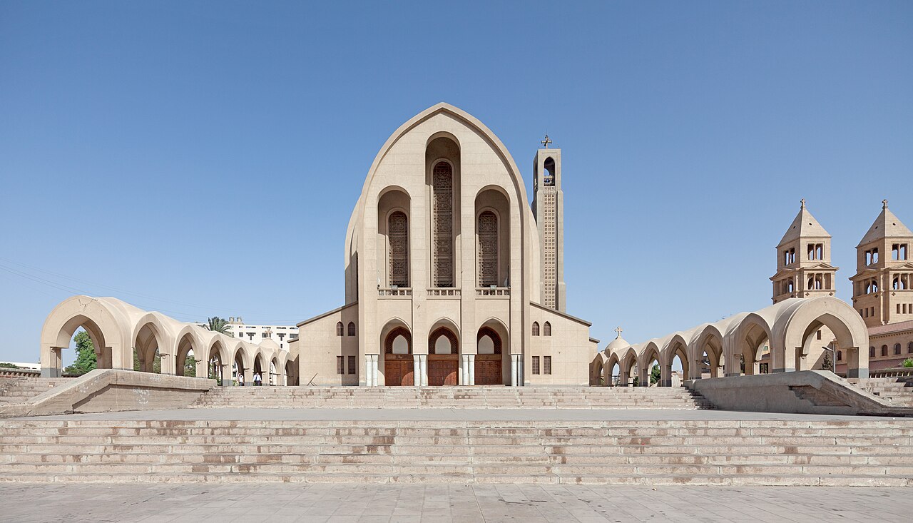 The grand arched facade of Saint Mark's Coptic Orthodox Cathedral in Cairo, flanked by its arcades and towers.