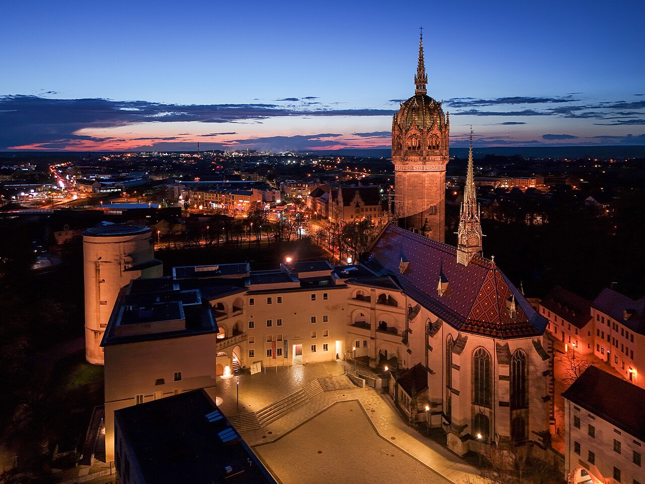 An aerial dusk view of Wittenberg's Castle Church and the old town around it.