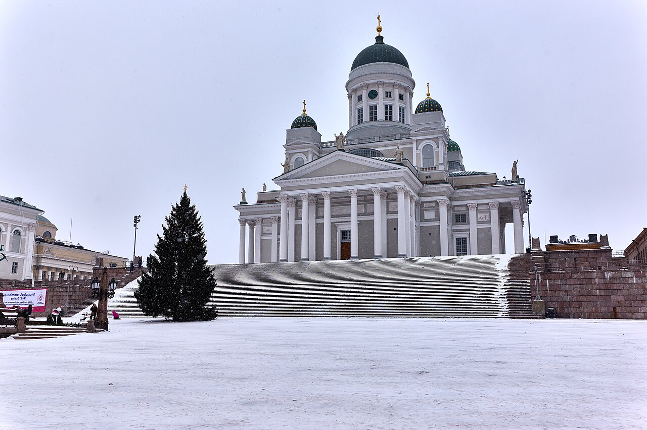 Helsinki Cathedral's white facade and green domes above a snow-covered Senate Square.