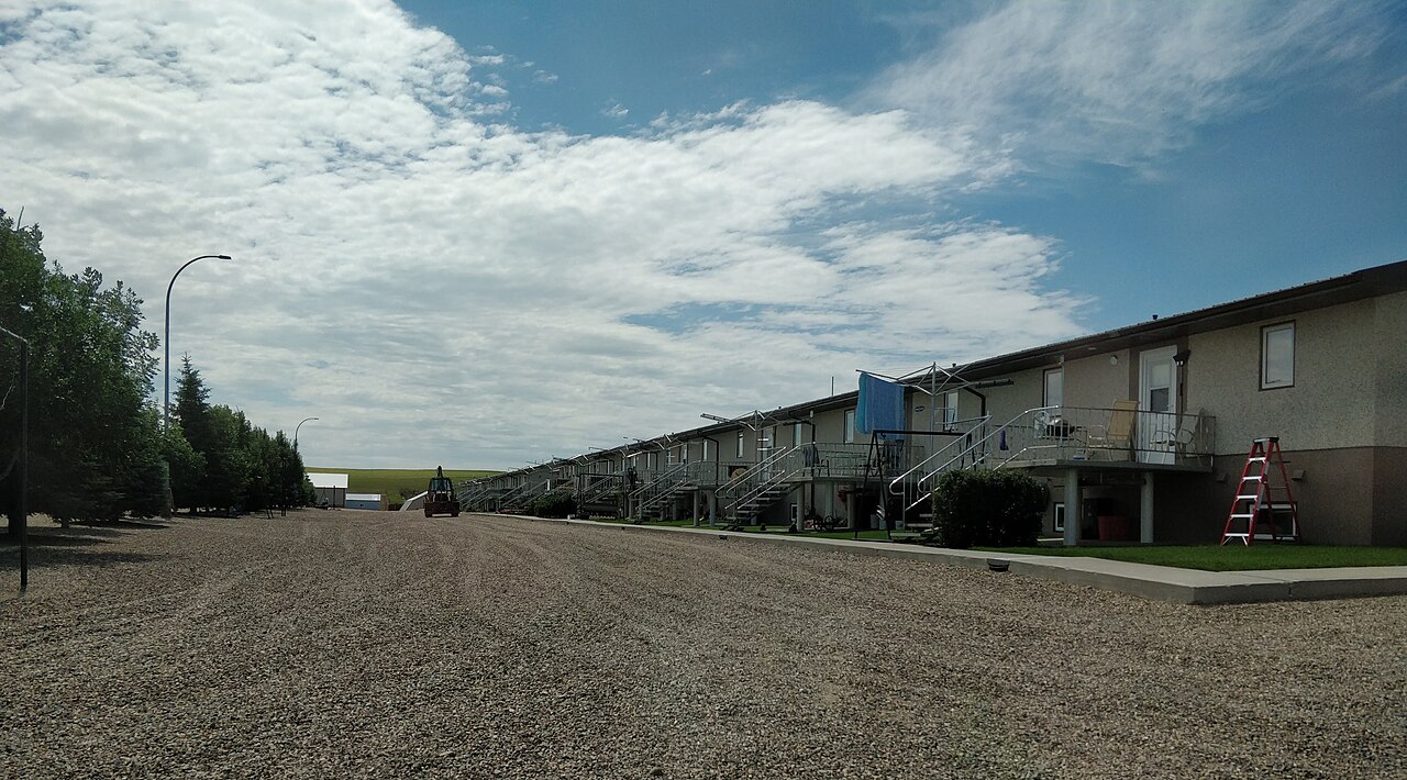 Communal row housing along a gravel road at the Sand Lake Hutterite Colony in Saskatchewan.