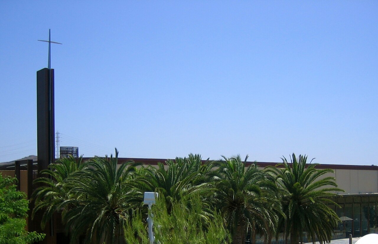 The Saddleback Church campus in Lake Forest, California, its cross-topped tower above palm trees.