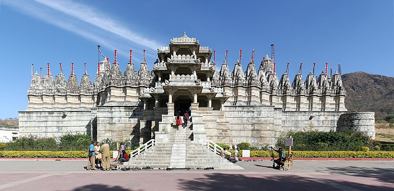 The white marble Ranakpur Jain temple, its many carved spires rising above a paved courtyard.