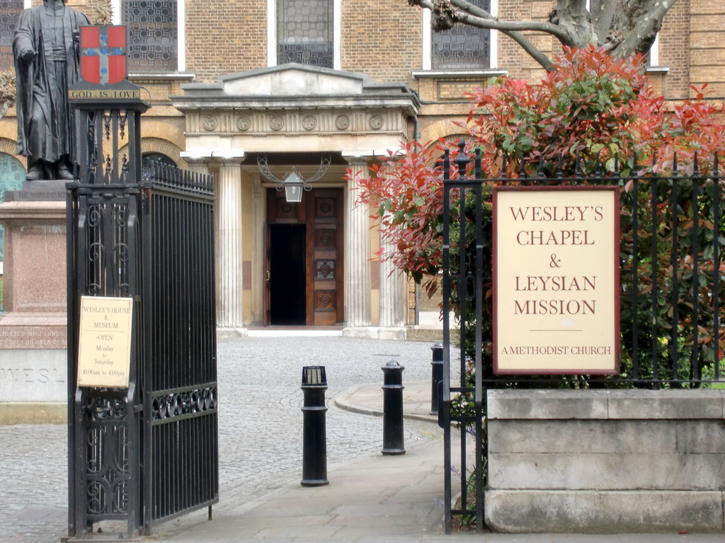 The gated entrance to Wesley's Chapel on City Road in London, Wesley's statue beside it.