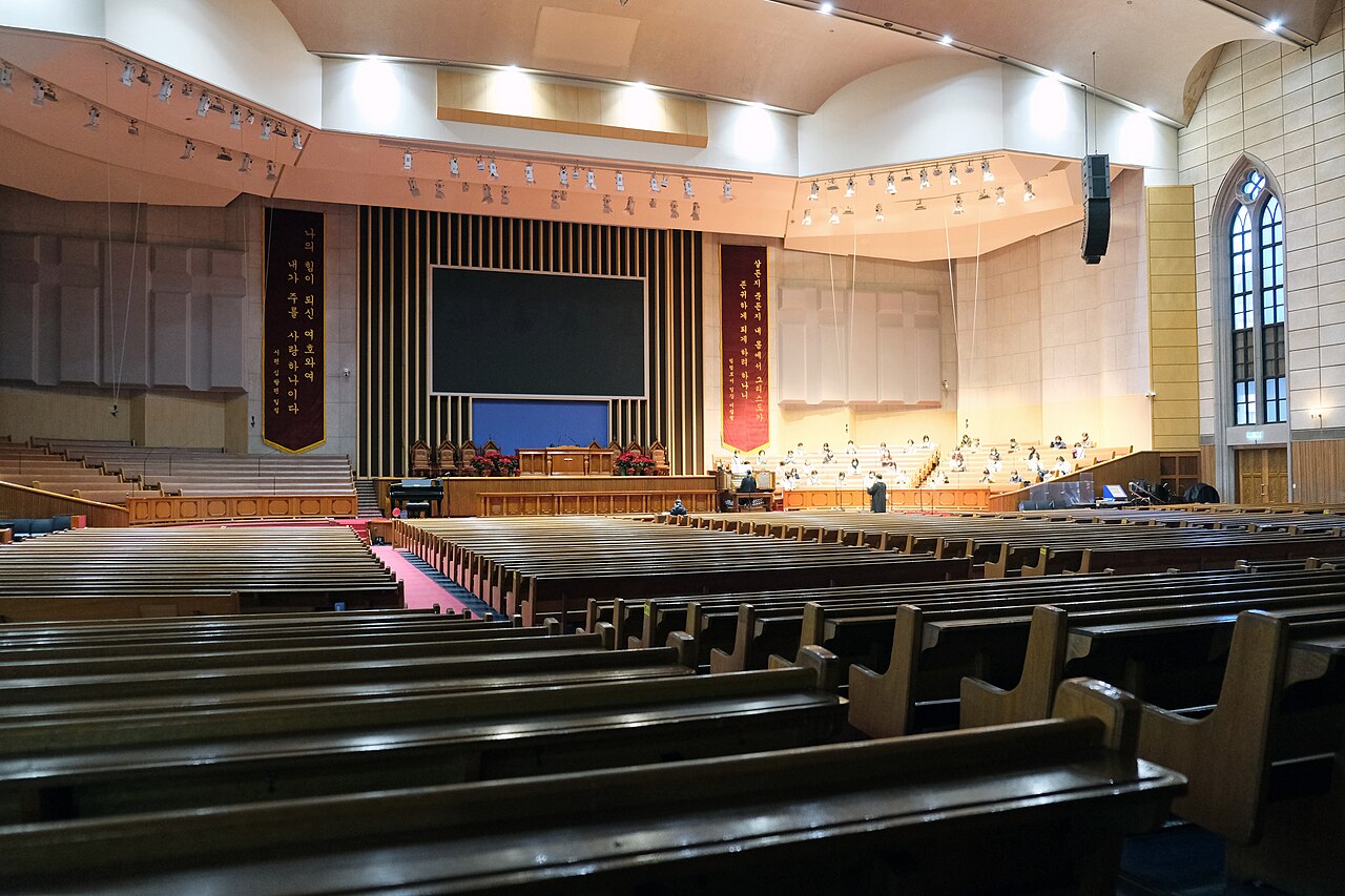 Rows of pews facing the broad platform inside Choong Hyun Presbyterian Church in Seoul.
