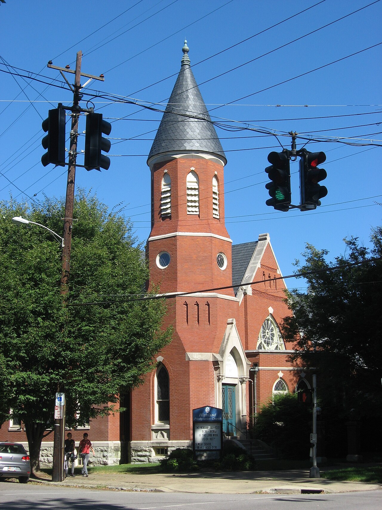 The red-brick spire of Highlands Presbyterian Church rising over a Louisville street corner.