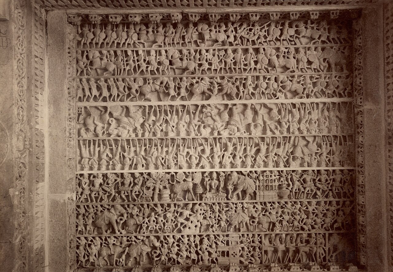 A marble panel in the Dilwara Temples at Mount Abu is carved with dense rows of small Jain figures and scenes.