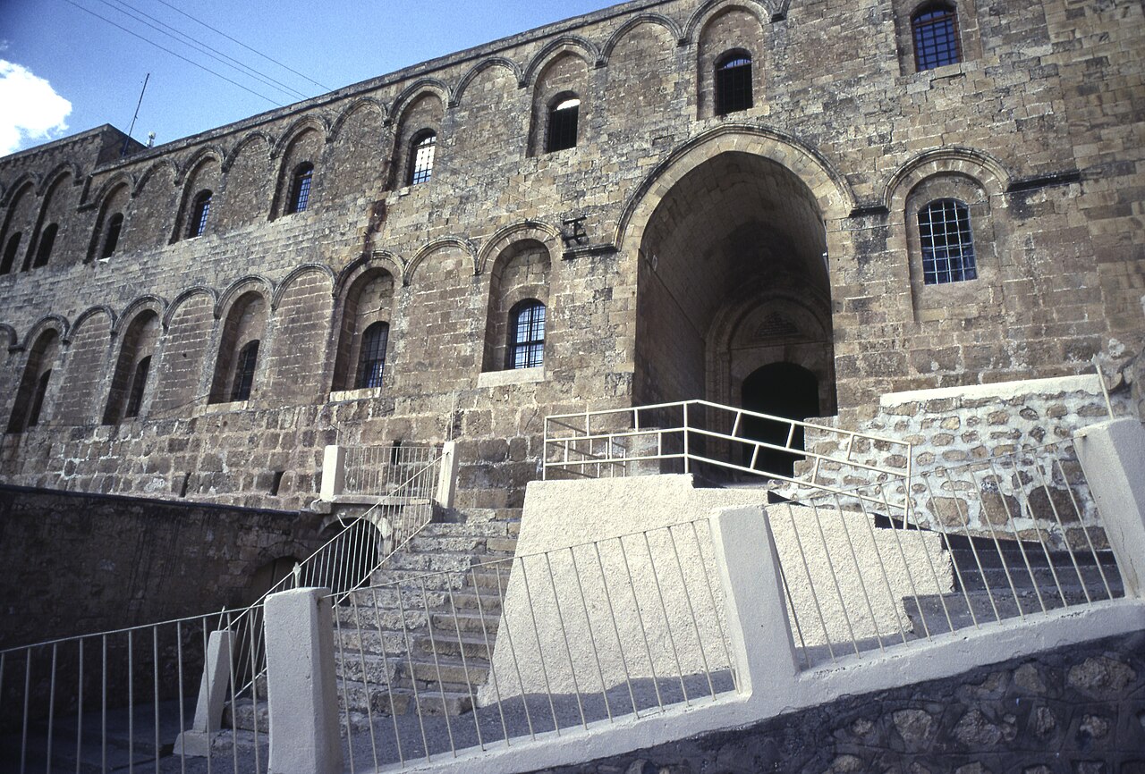 The ancient arched stone facade and entrance stairs of Mor Hananyo Monastery near Mardin.