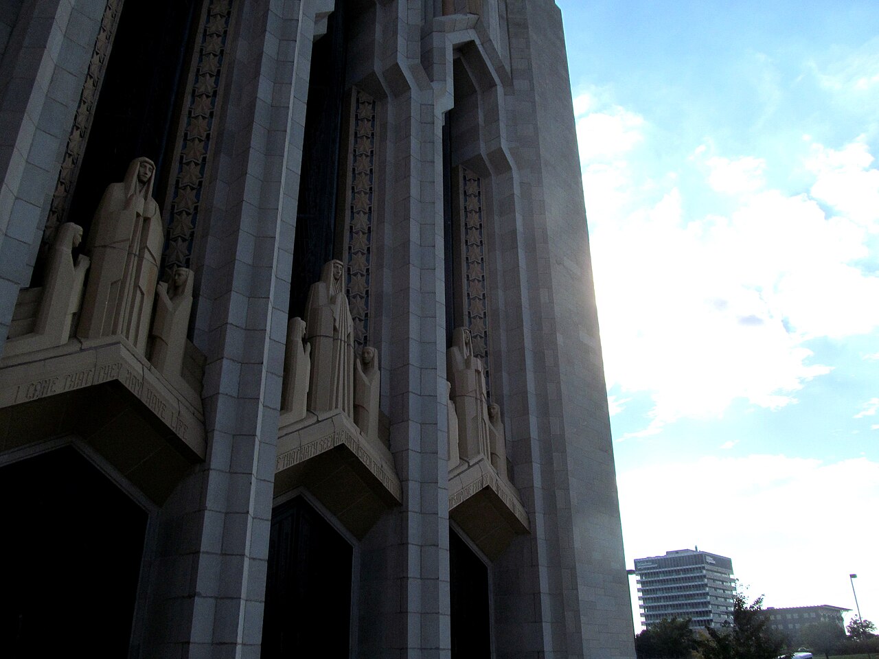 Looking up at the art deco tower of Boston Avenue Methodist Church in Tulsa, carved figures near its top.