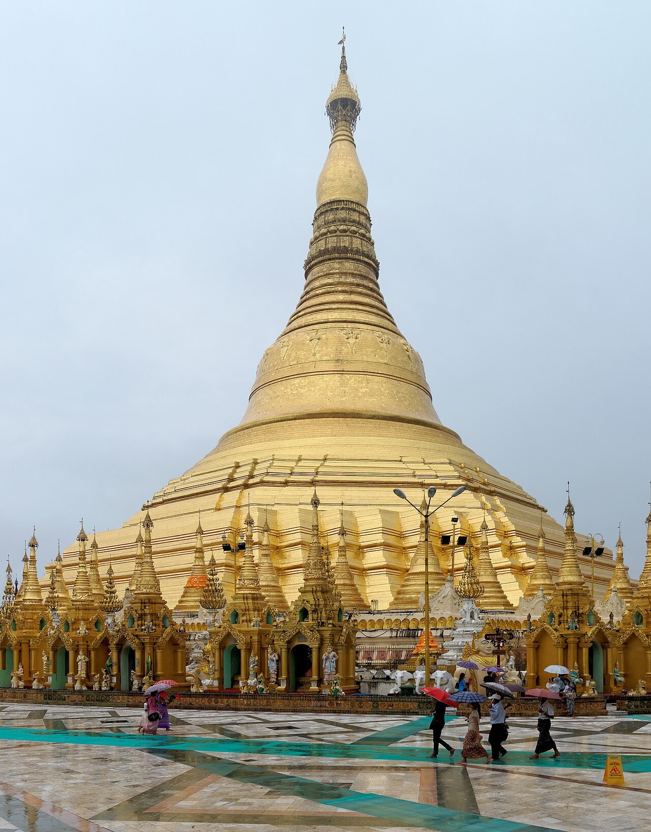 The golden stupa of Shwedagon Pagoda in Yangon towers over its terrace and visitors.