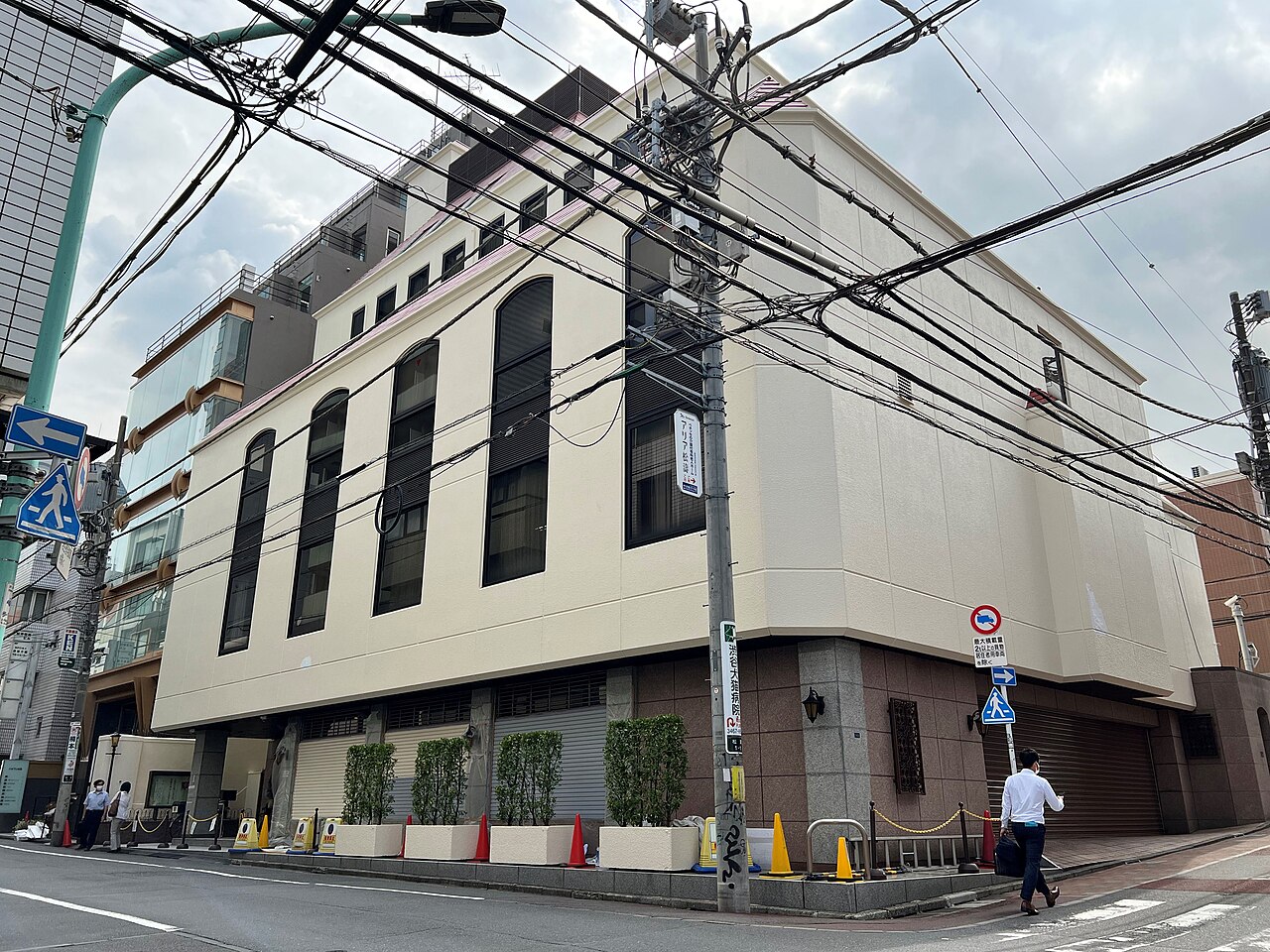 The Family Federation for World Peace and Unification headquarters building in Japan, a modern beige block on a city street corner.