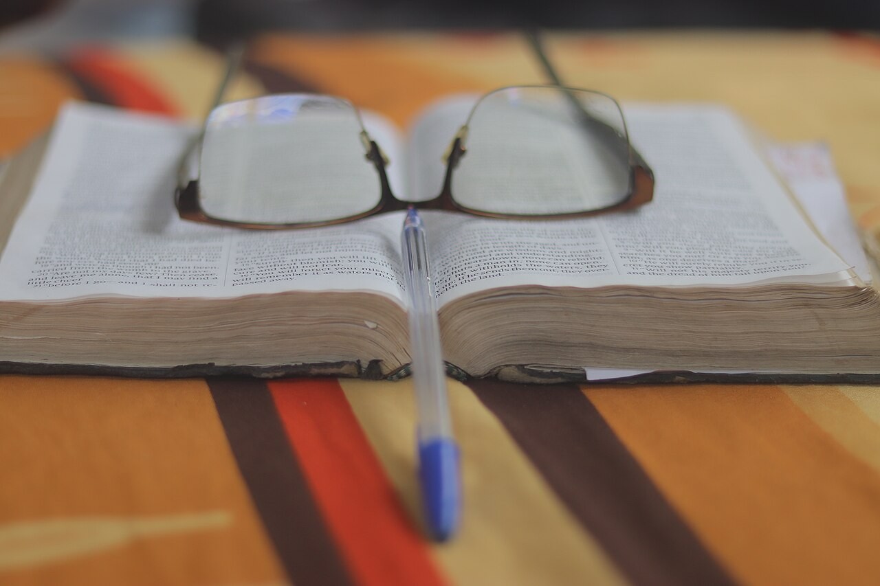 An open Bible, its pages filled with the text reading plans work through.
