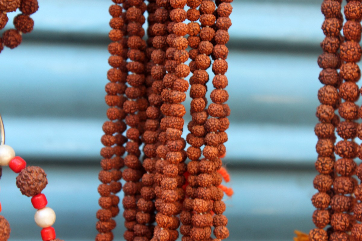 Hands at prayer with a rudrākṣa japa mālā, the strand of 108 beads.