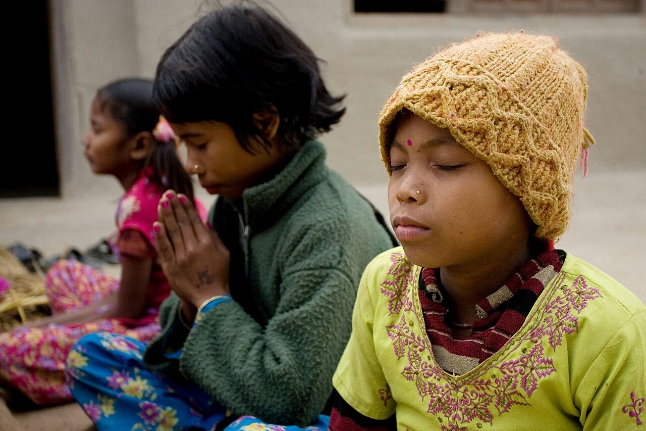 A Bahá'í devotional gathering in East Kanchanpur, Nepal, with prayers read together.