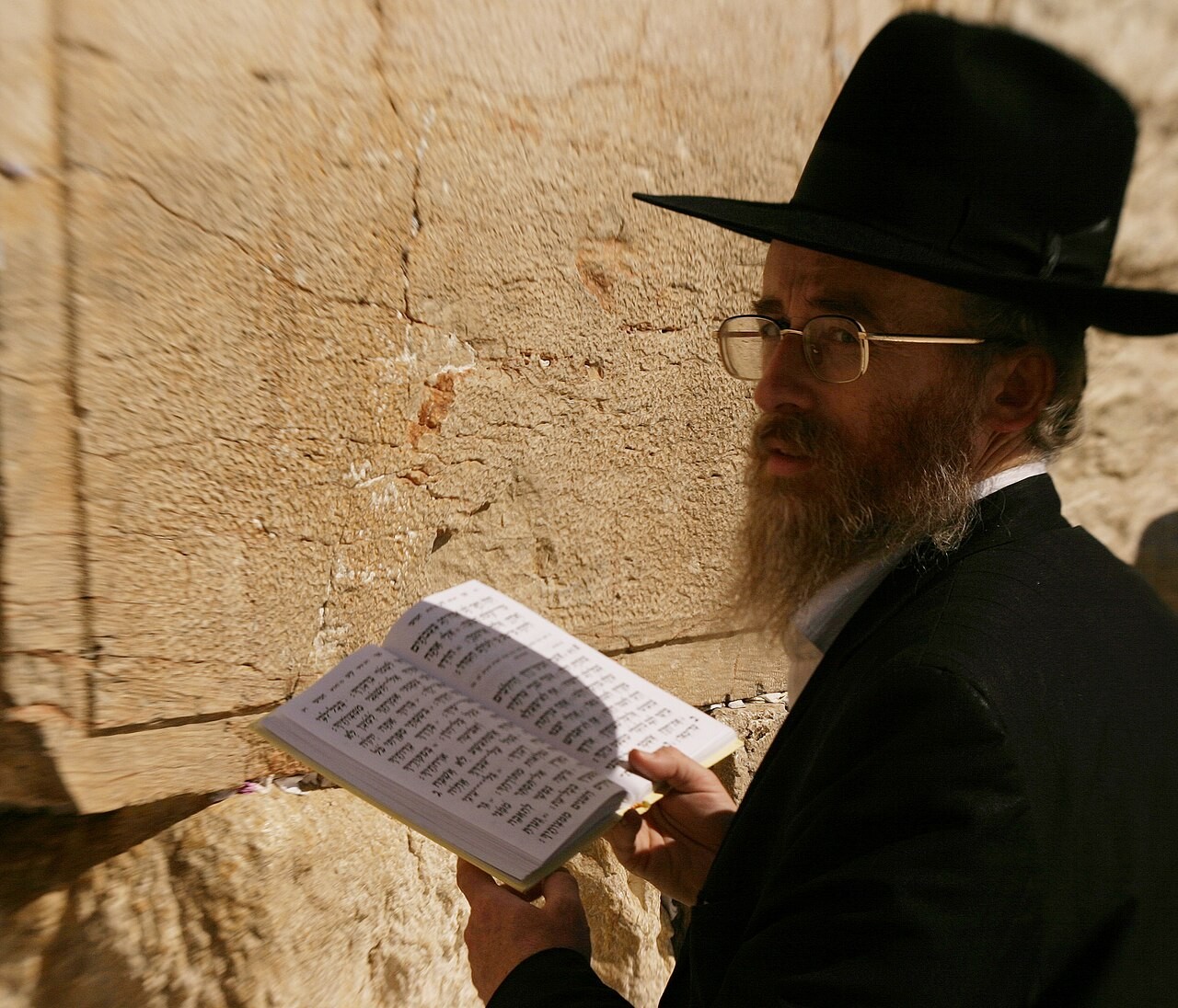 A worshipper reciting from a book of Psalms at the Western Wall in Jerusalem.