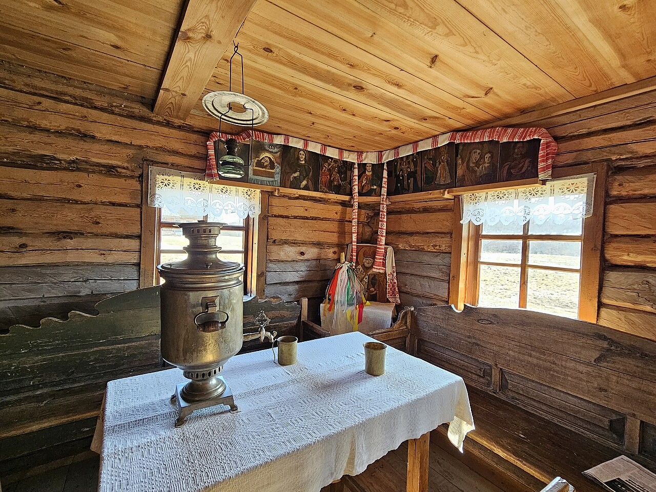 A traditional Orthodox icon corner in a Belarusian home, with icons and a hanging lamp.