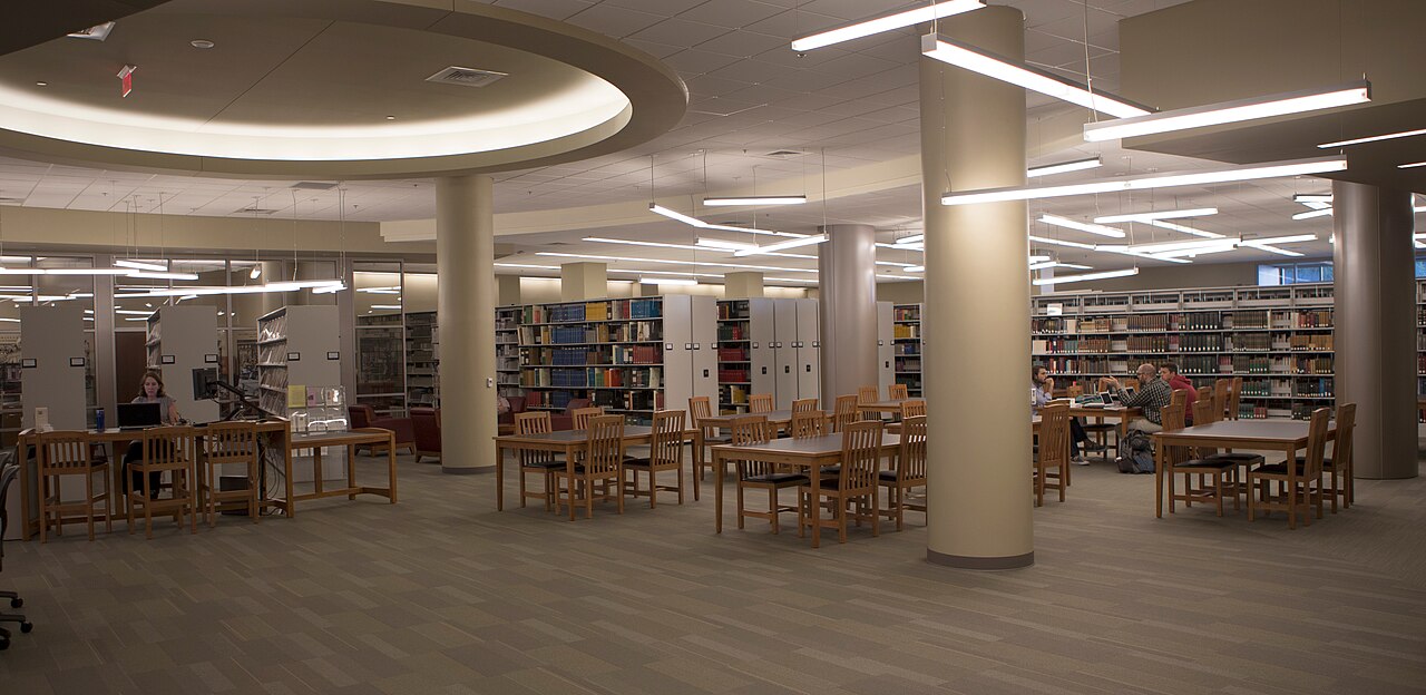 The main reading room of Pitts Theology Library at Emory University, with long study tables and book stacks.