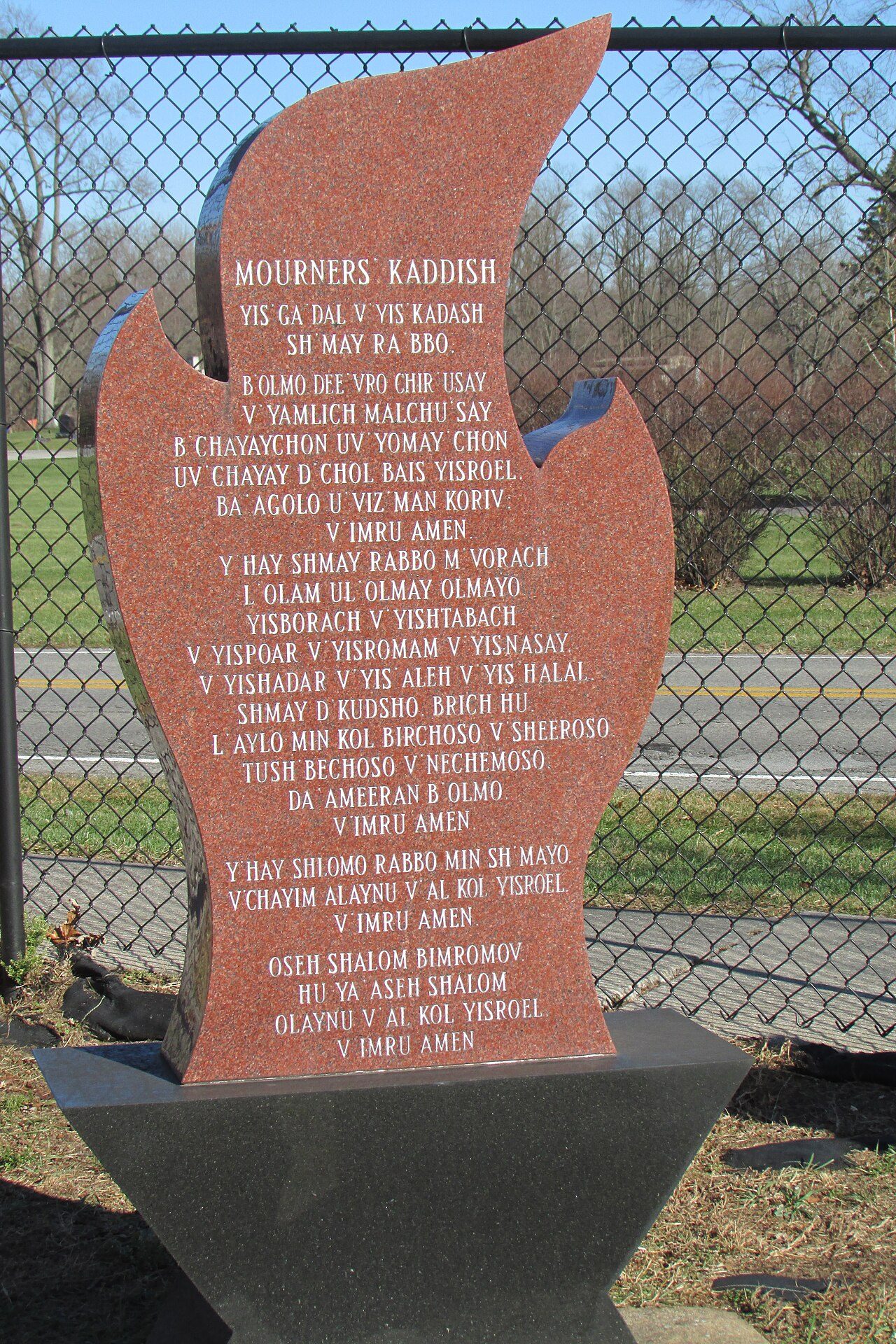 A flame-shaped memorial stone carved with the Mourner's Kaddish