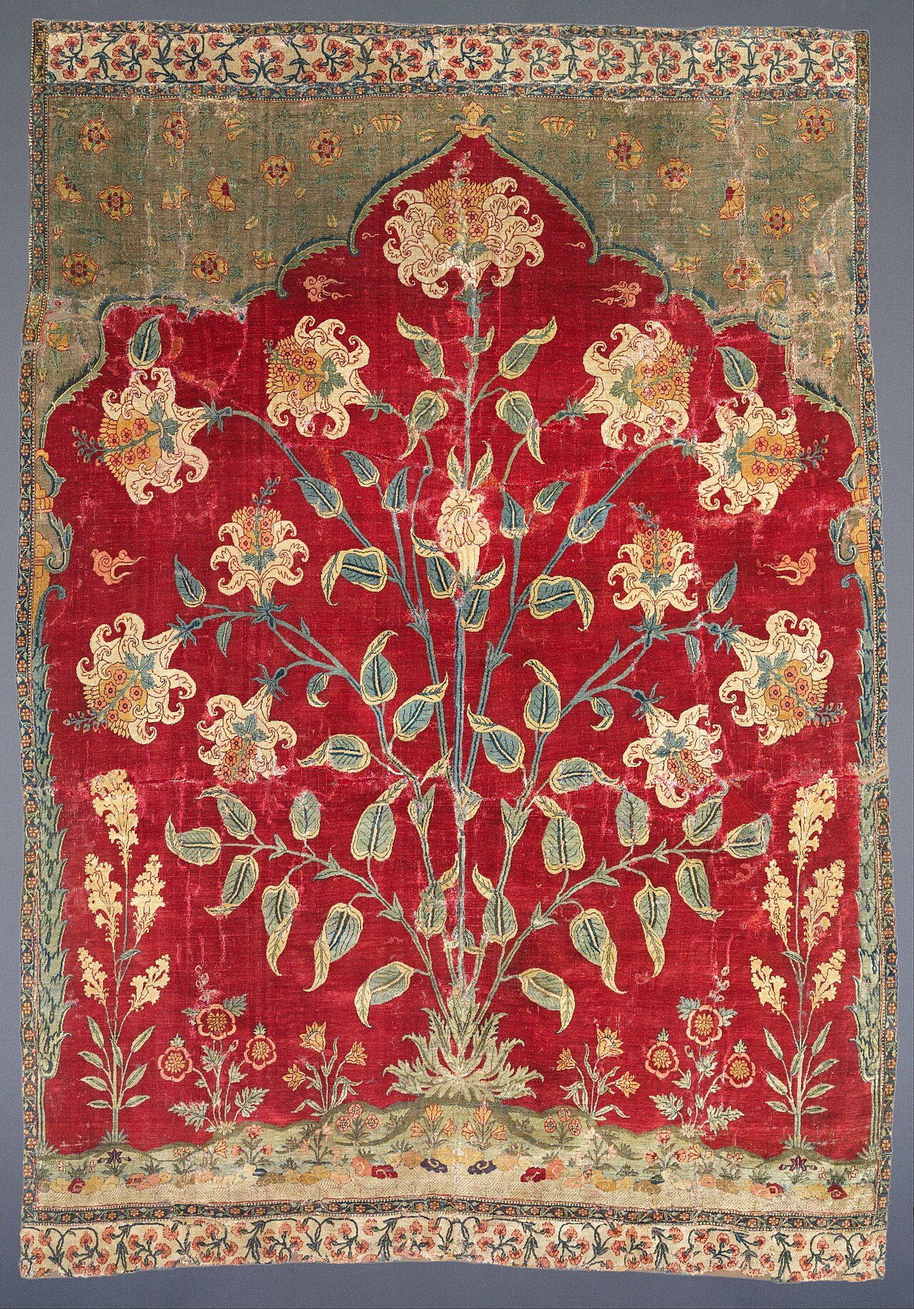 A Mughal prayer carpet with a mihrab arch