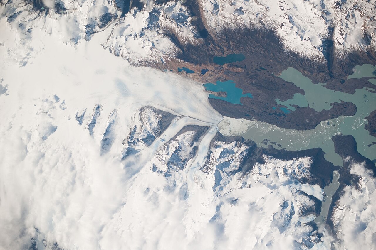 A satellite view of the retreating Upsala Glacier, pale ice streaked with meltwater lakes.