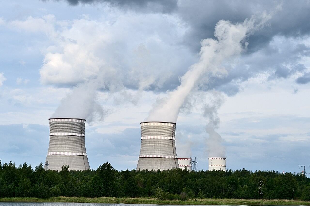 Two hyperboloid cooling towers venting steam at a nuclear power plant.