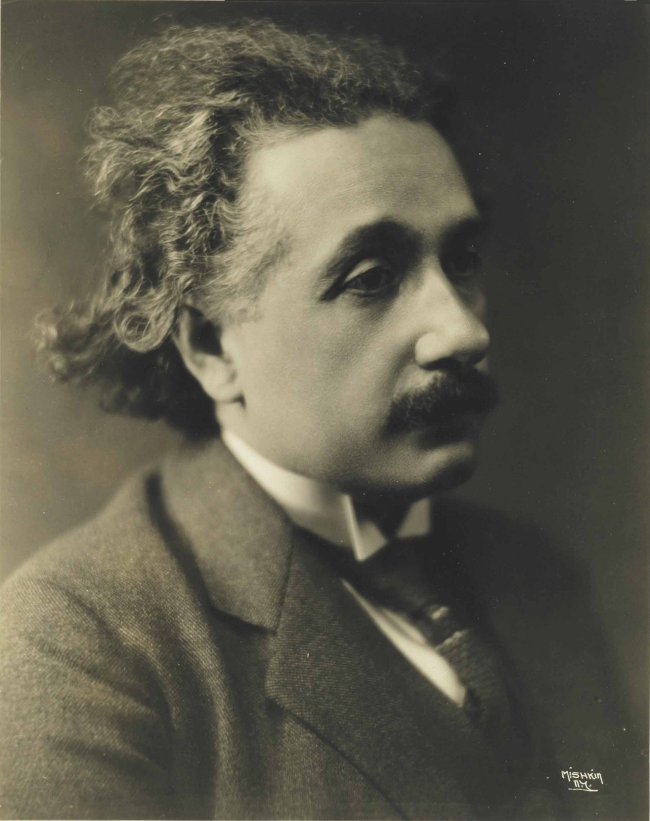 Herman Mishkin's 1921 photograph of Albert Einstein in profile, wavy-haired and moustached.