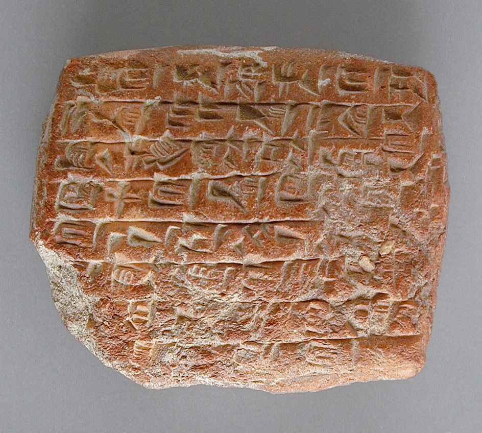 A clay tablet from ancient Mesopotamia covered with wedge-shaped cuneiform signs pressed into its surface.