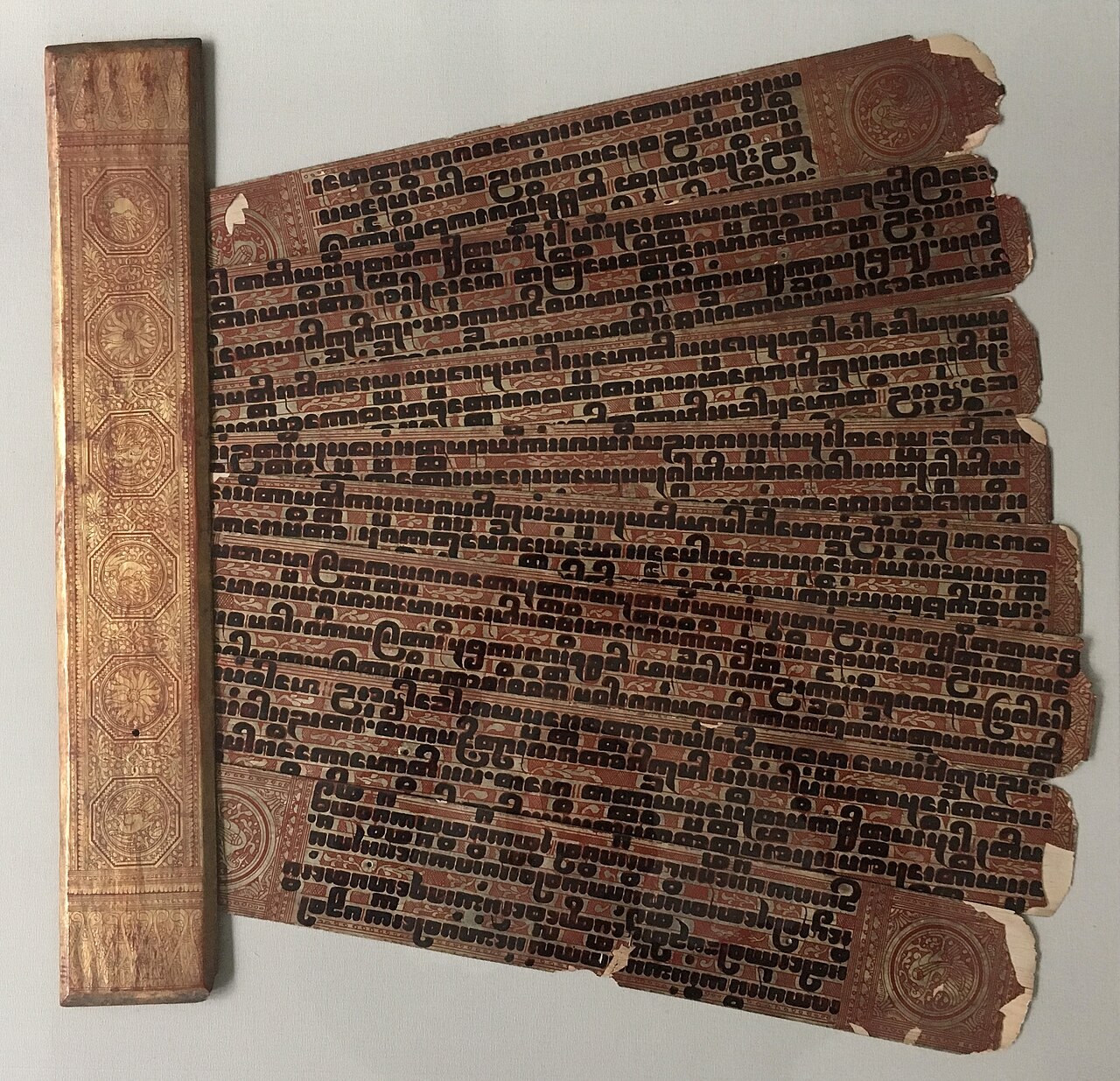 A Burmese Kammavaca manuscript, its lacquered palm leaves covered with Pali text in the ornate Burmese tamarind-seed script.