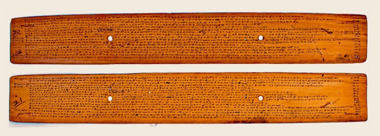 Two palm-leaf manuscript folios densely inscribed with Tamil writing, the letters incised in long horizontal lines.