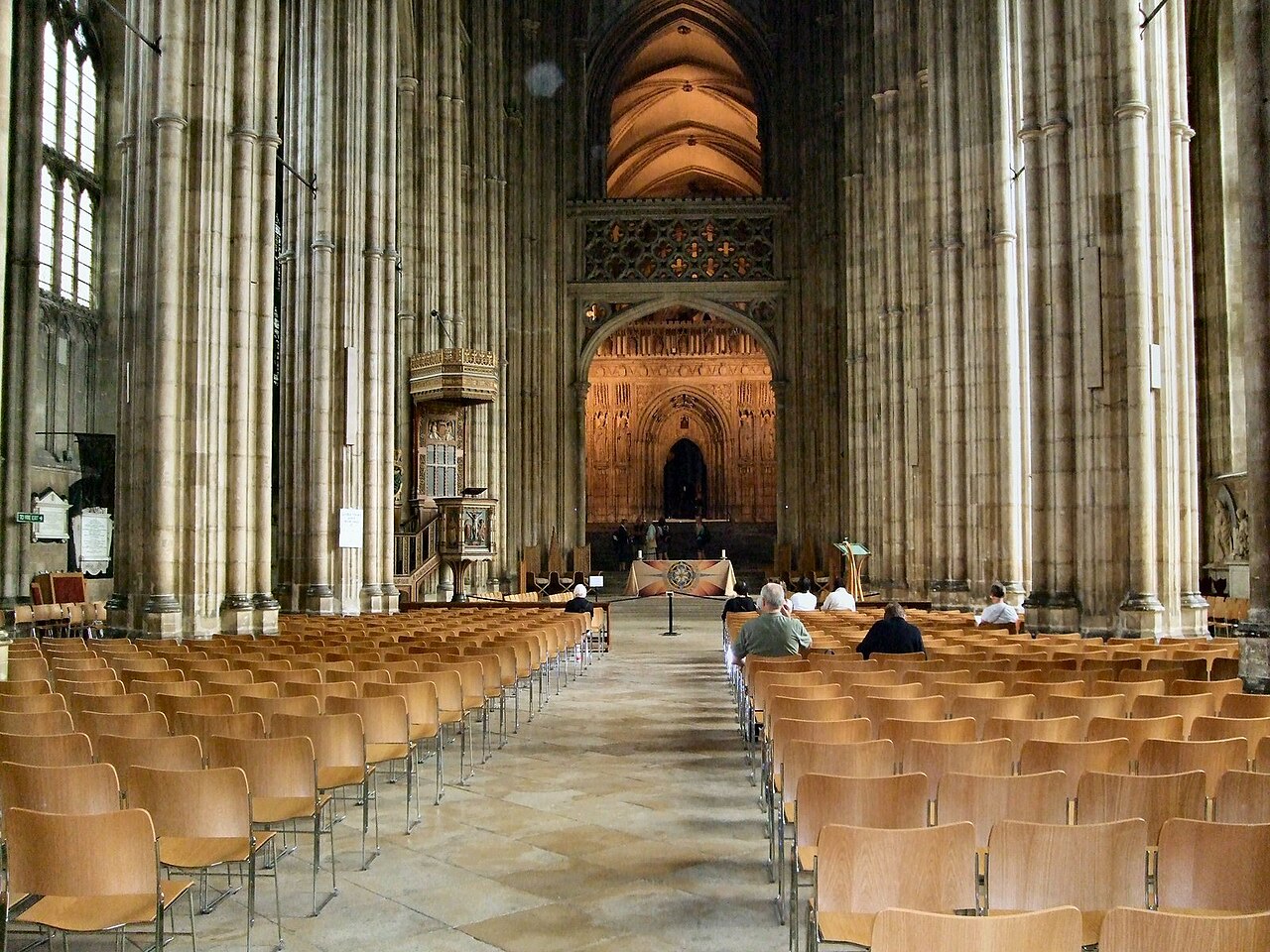 The nave of Canterbury Cathedral, rows of chairs running toward the screen and the tower crossing.