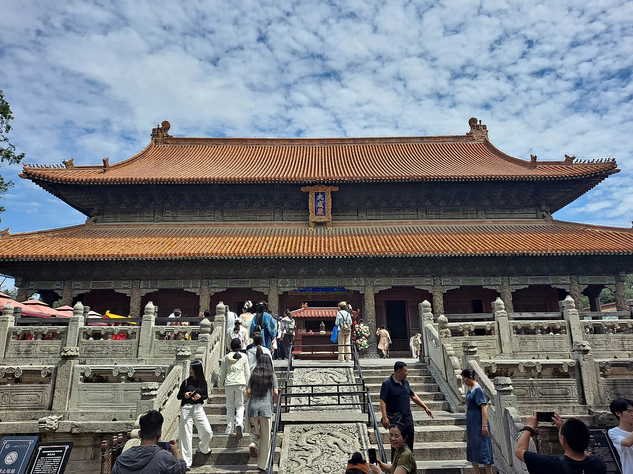The Dacheng Hall of the Temple of Confucius at Qufu, its double orange-tiled roof above the carved stone terrace and dragon pillars.