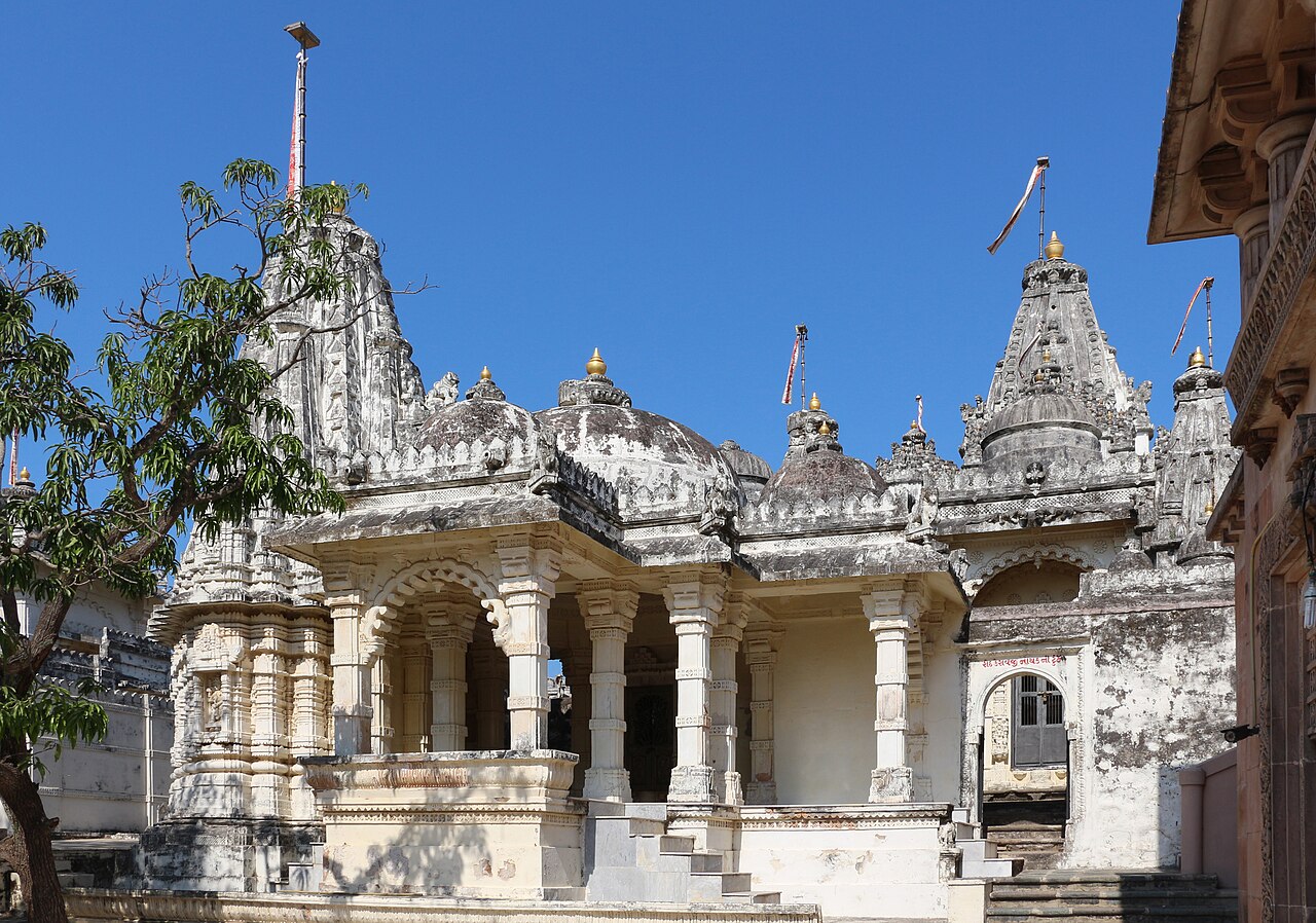 White marble Jain temples with carved spires and domes cluster on the sacred hill of Palitana in Gujarat.