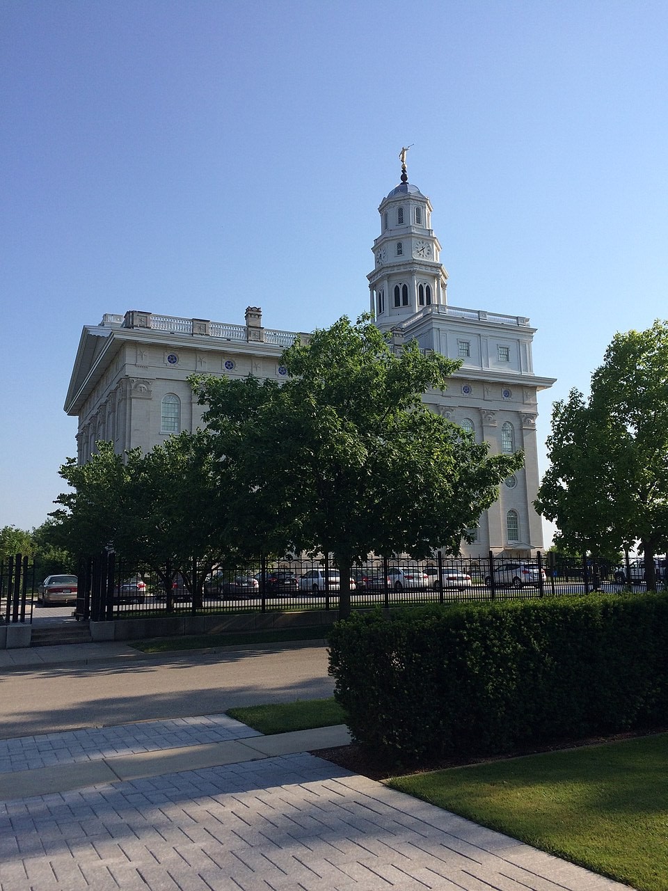The Nauvoo Illinois Temple, its white tower topped by the Angel Moroni, seen from the street below.