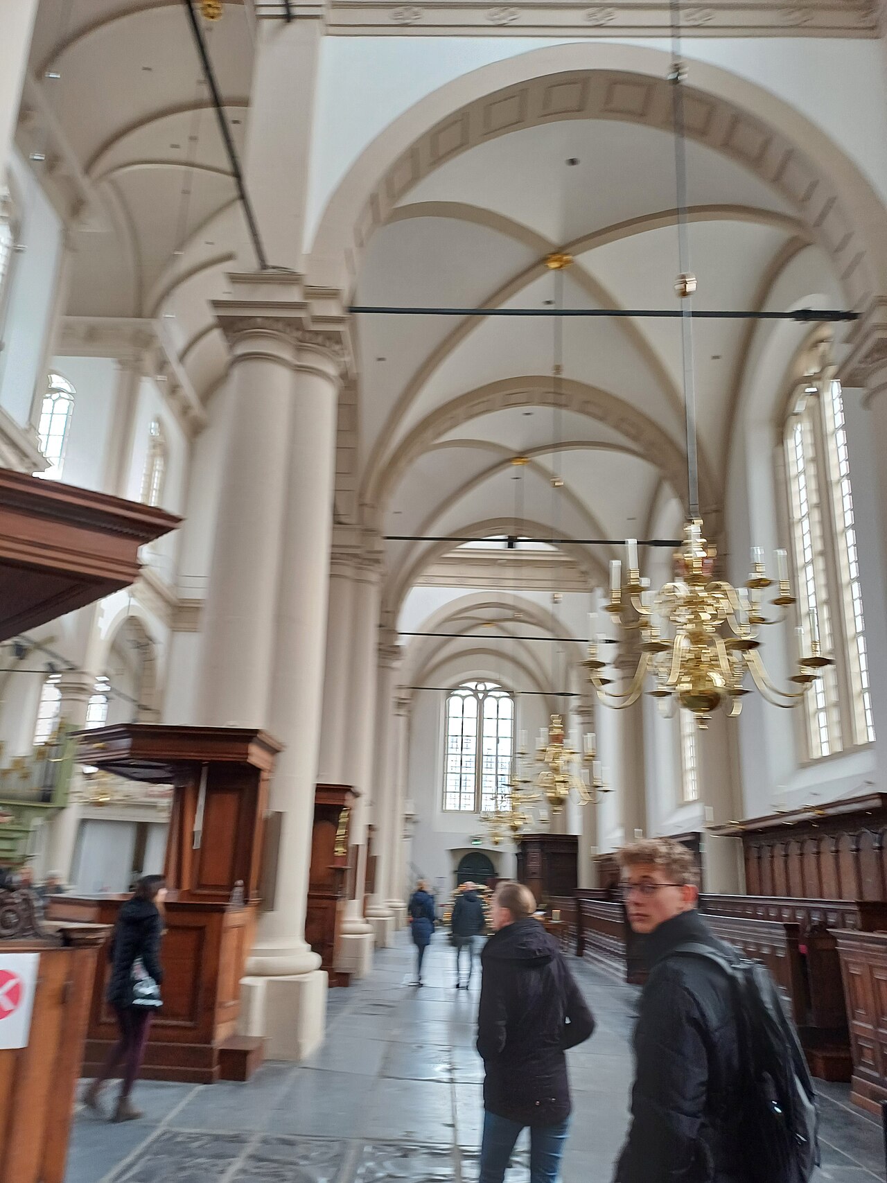 The white-columned interior of the Westerkerk in Amsterdam, its chandeliers hanging over the nave.